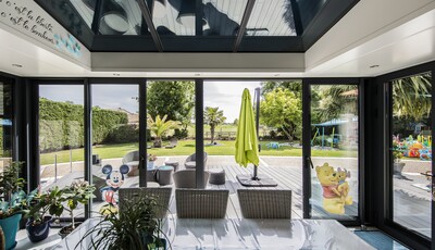 Véranda Akena équipée de vitrage électrochrome SageGlass. Le vitrage SageGlass est teinté, bloquant ainsi l'éblouissement dans la pièce.