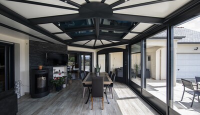 Véranda Akena équipé de vitrage SageGlass. Le vitrage est teinté à son niveau maximal ce qui empêche le soleil de causer de l'éblouissement dans la pièce.