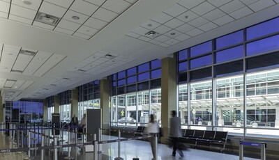 Inside a commercial building with people walking and seating and queues.
