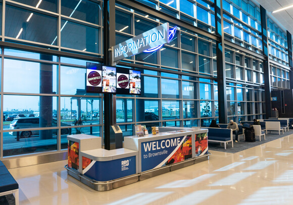 Interior of airport information desk with custom smart glass windows from left to right. 