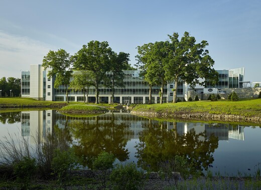 Exterior of architectural building with custom smart glass windows overlooking water. 