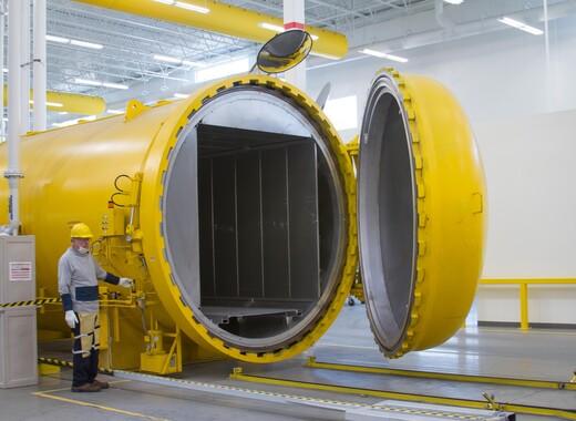 Interior of manufacturing plant with worker manning machine in smart glass powerplant. 