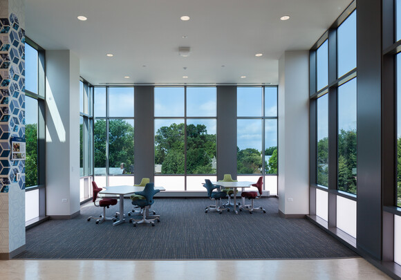 Interior common space of office building with huge smart glass windows from left to right. 
