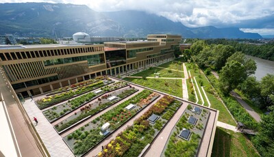 Exterior of the building behind a grass quad with custom smart glass windows. 