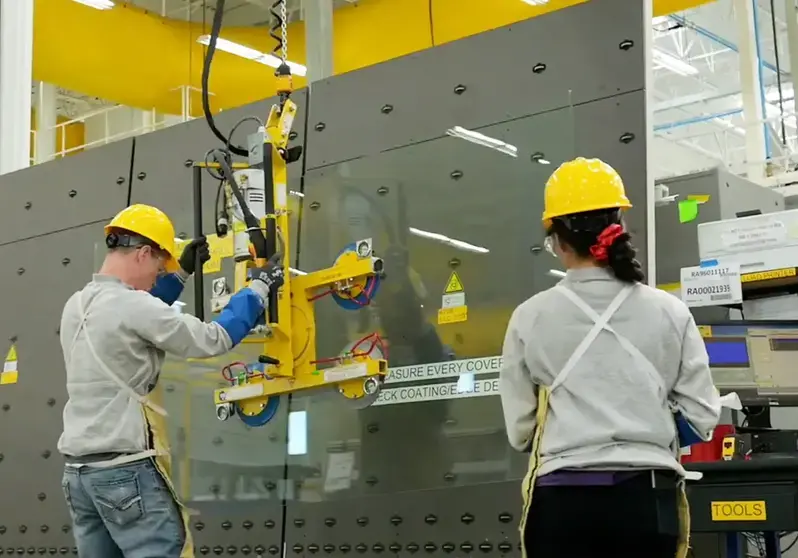 Industrial workers with yellow hard hats working and measuring deck coatings with tools.